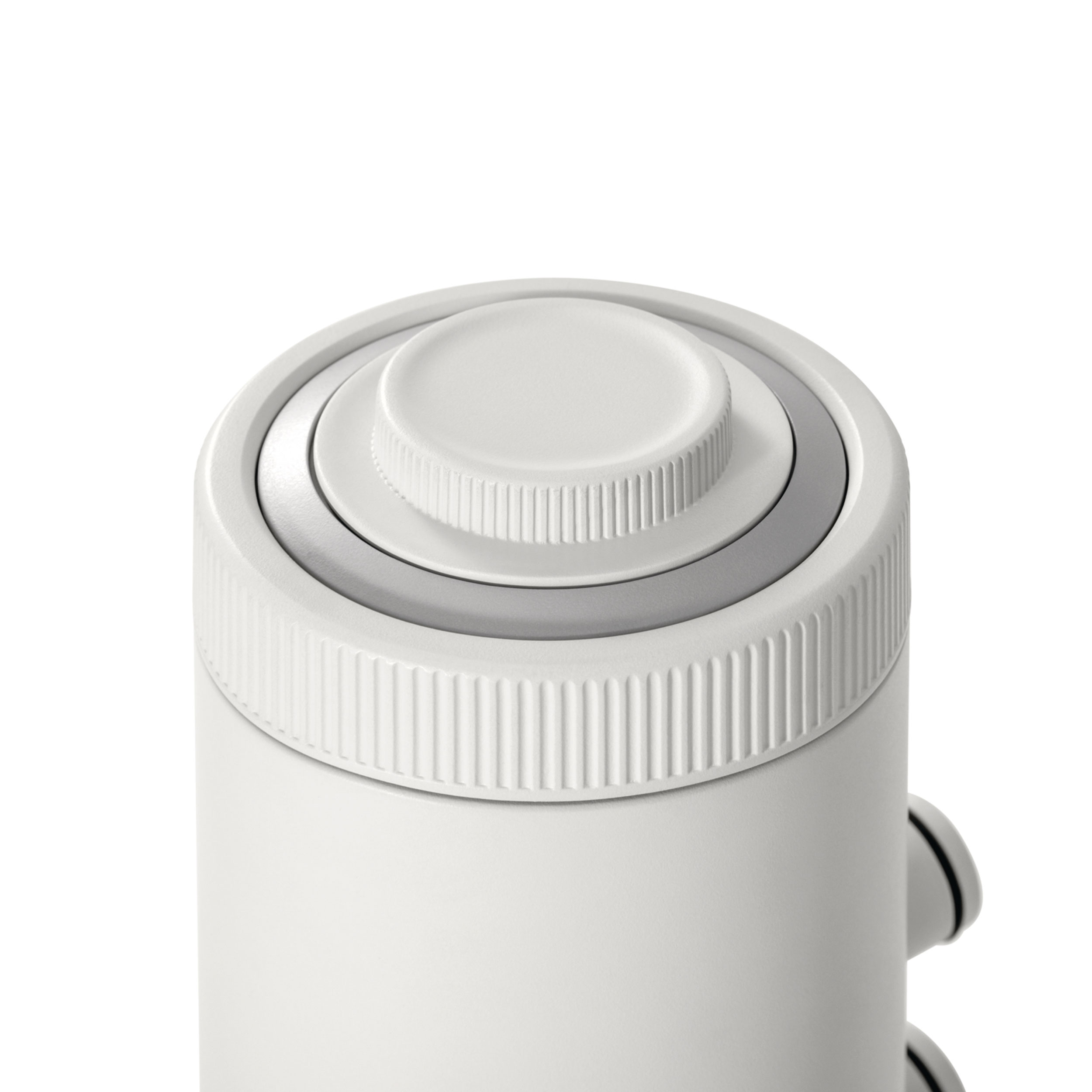 Górna część białego urządzenia z centralnym, żłobkowanym pokrętłem i srebrnym pierścieniem.