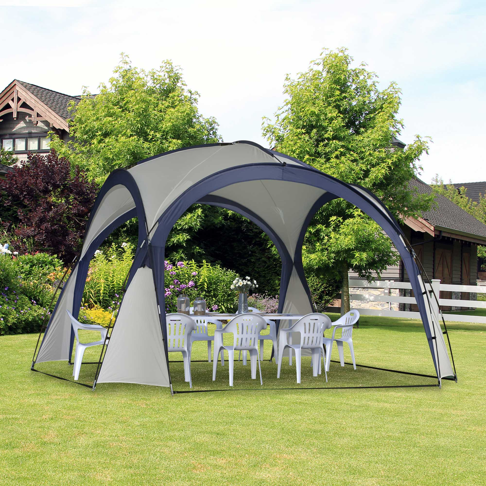 Ein Baldachinzelt auf Rasen aufgebaut, mit Tisch und Stühlen darin.