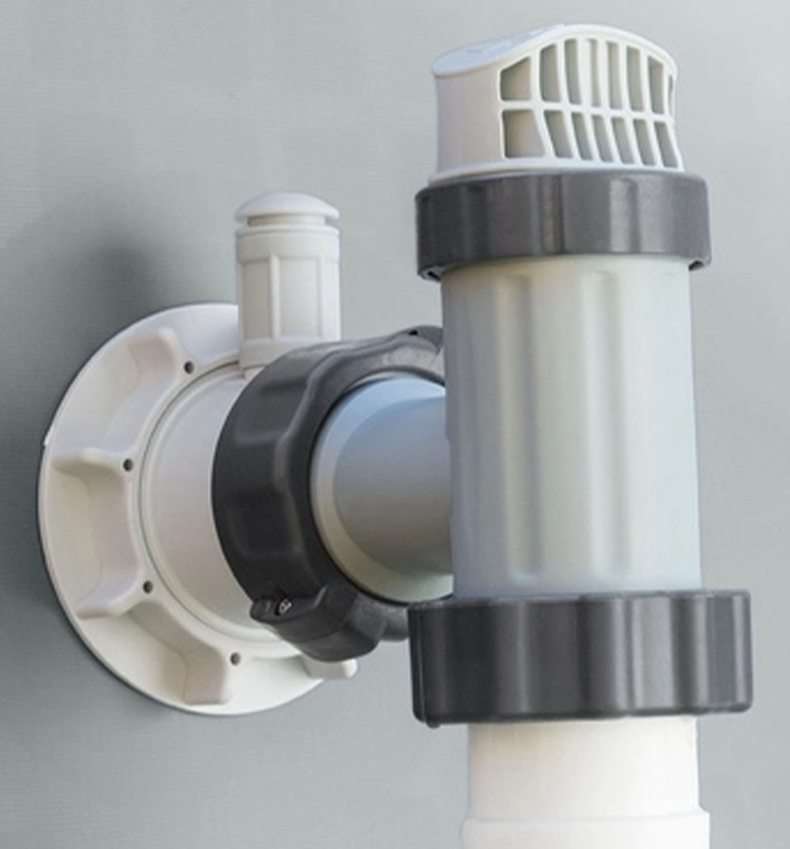 Zbliżenie wlotu wody do basenu. Wlot jest biały i ma czarną, obrotową część.