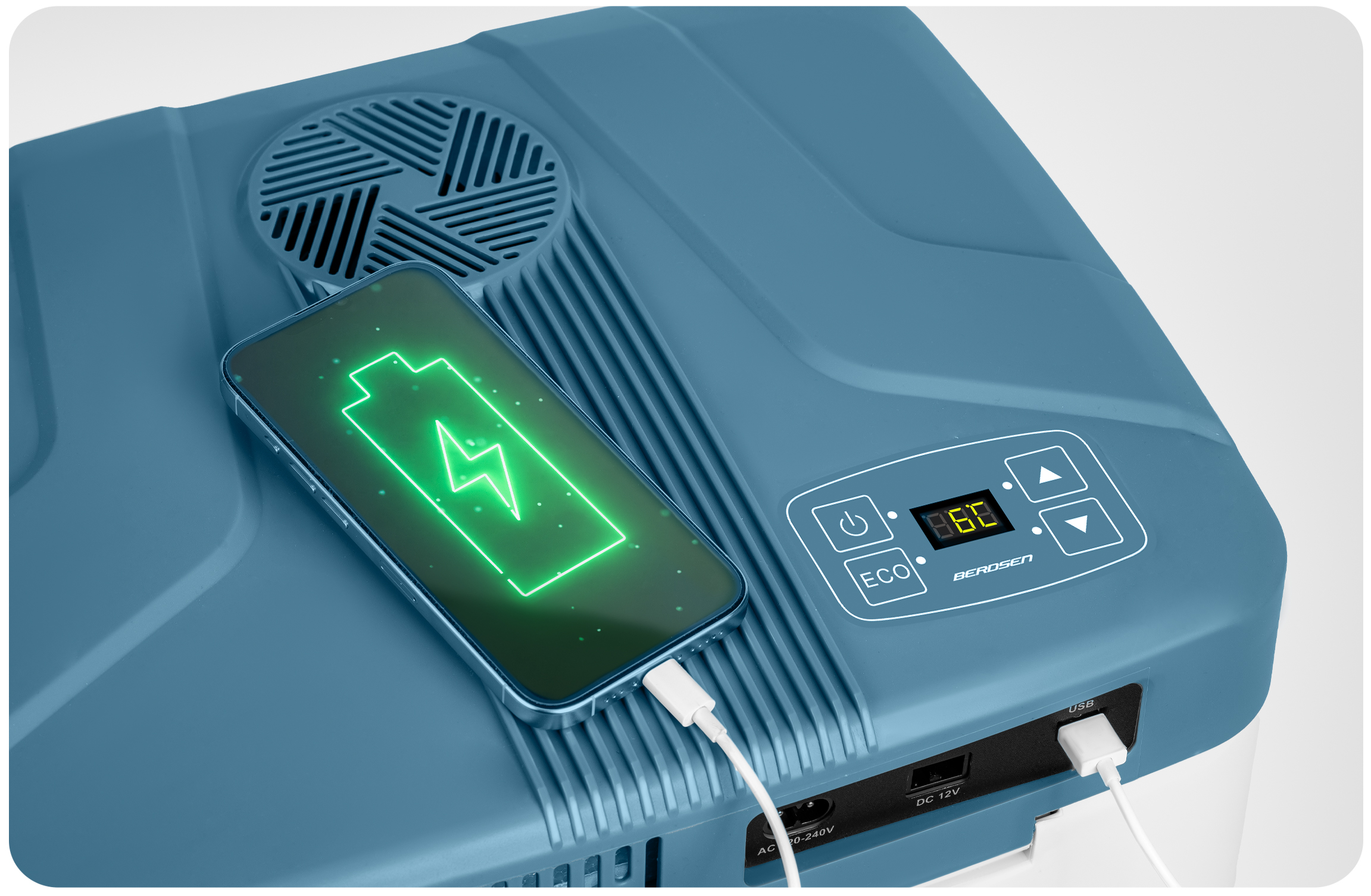 Niebieska lodówka z telefonem ładującym się na górze. Telefon wyświetla zieloną ikonę ładowania baterii. Lodówka ma cyfrowy wyświetlacz.