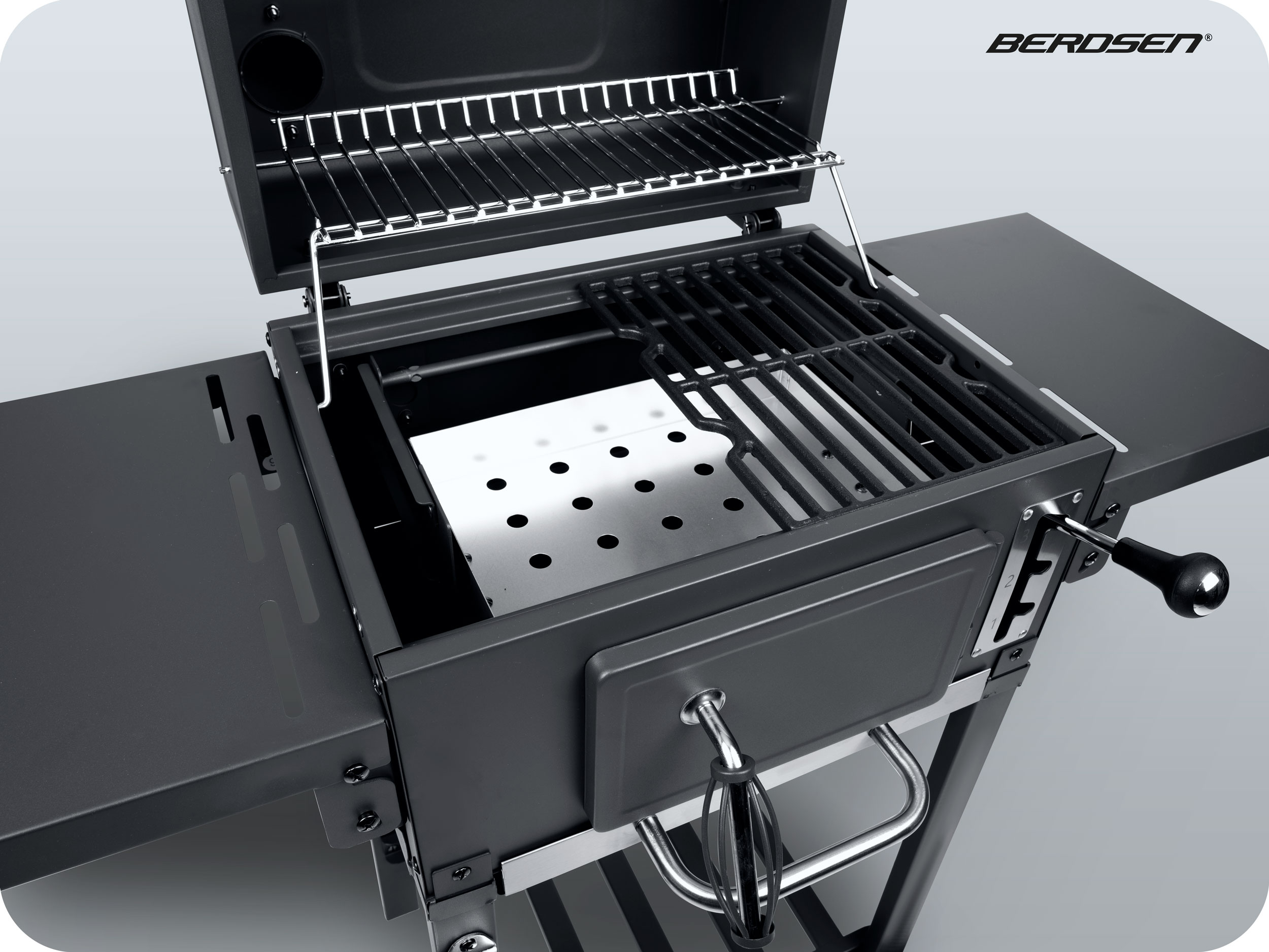 Grill węglowy jest otwarty, pokazując ruszty i palenisko. Tło jest jasnoszare.