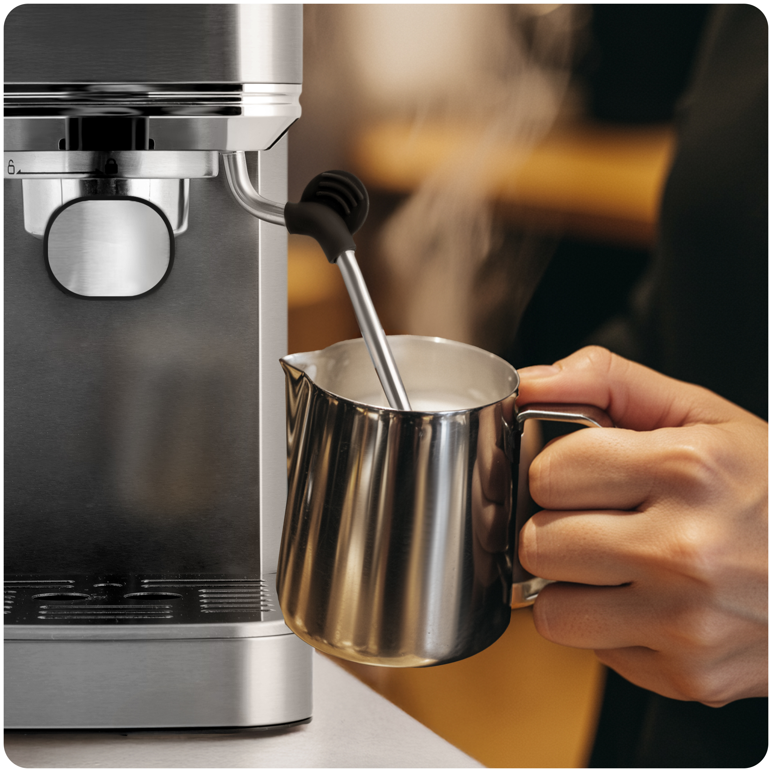 Osoba używająca ekspresu do kawy. Para unosi się z mleka w metalowym dzbanku.
