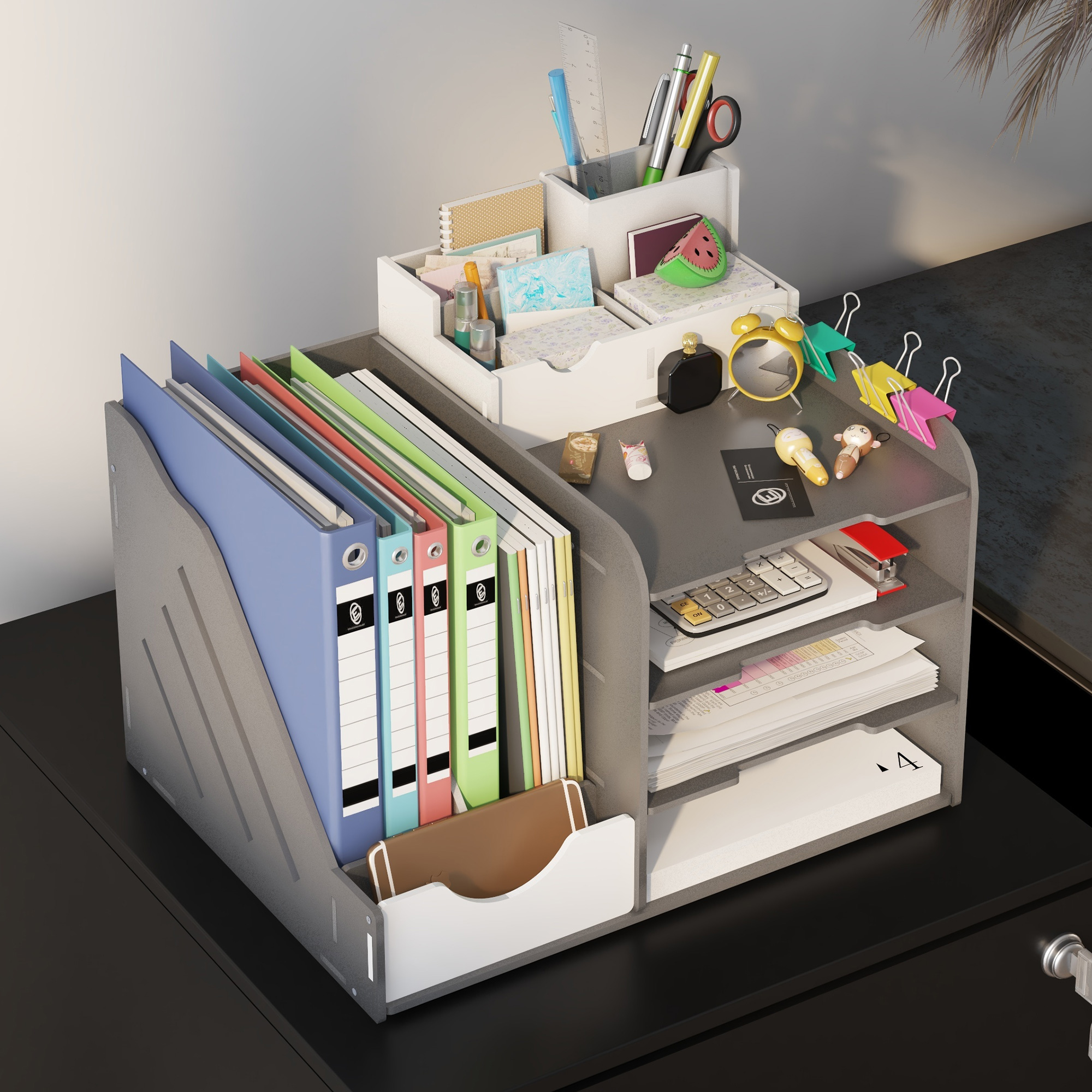 Schreibtisch-Organizer mit Bürobedarf. Er enthält Ordner, Stifte, Papier und Dekoration. Schwarzer Schreibtischhintergrund.