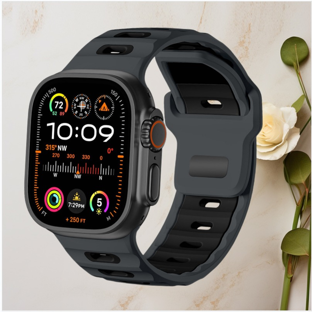 Schwarze Smartwatch mit blauem Armband, zeigt Zeit, Kompass und Gesundheitsmetriken, mit floralem Hintergrund.