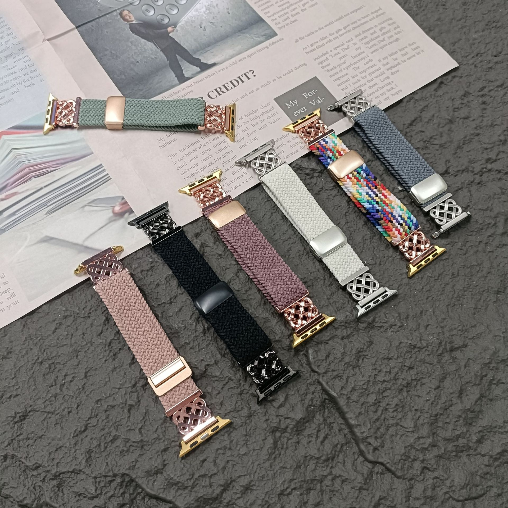 Sortiment von Apple Watch-Armbändern in verschiedenen Farben, auf Zeitungshintergrund, verschiedene Stile.