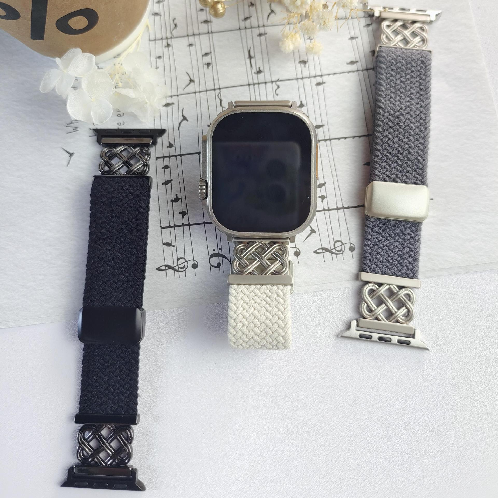 Drei Uhrenarmbänder. Eines schwarz, eines weiß und eines grau. Alle haben dekorative Verschlüsse. Die Uhr ist silber.
