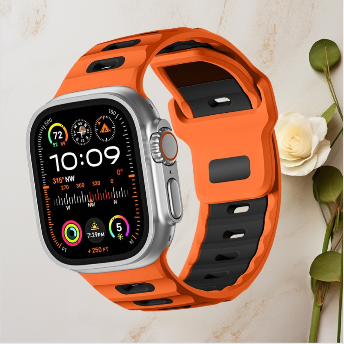 Silberne Smartwatch mit orangefarbenem Armband, zeigt die Uhrzeit, mit einer Blume in der Ecke.