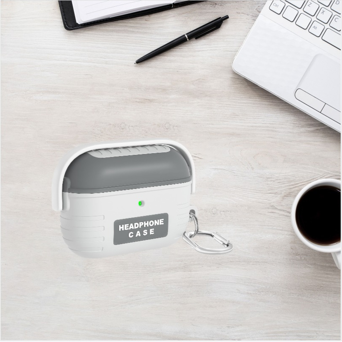 Estuche de auriculares blanco y gris con clip plateado sobre un escritorio con laptop y café.