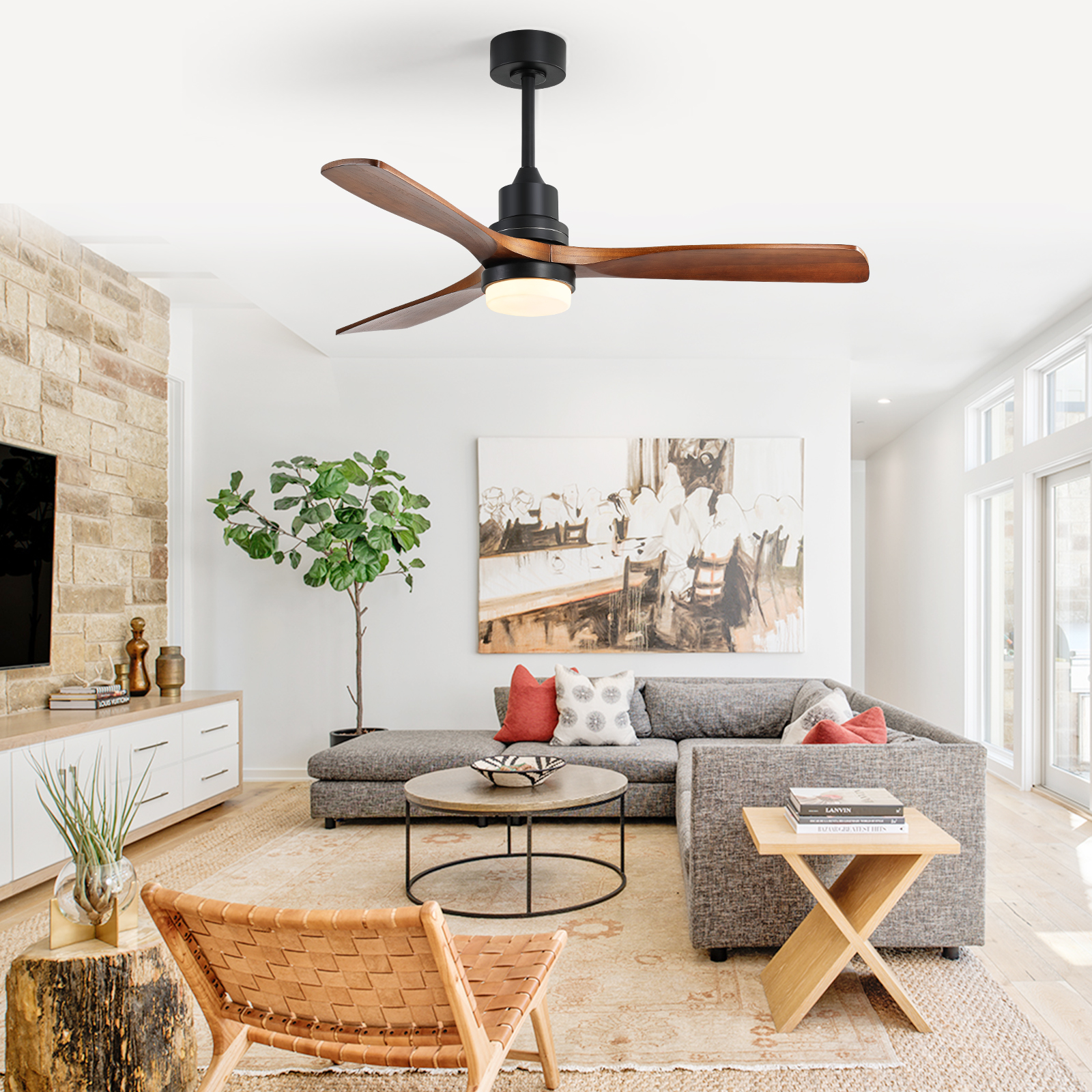 Wohnzimmer mit Deckenventilator, Ledersessel, grauem Sofa und Baum. Neutrale Töne mit einer Backsteinmauer.