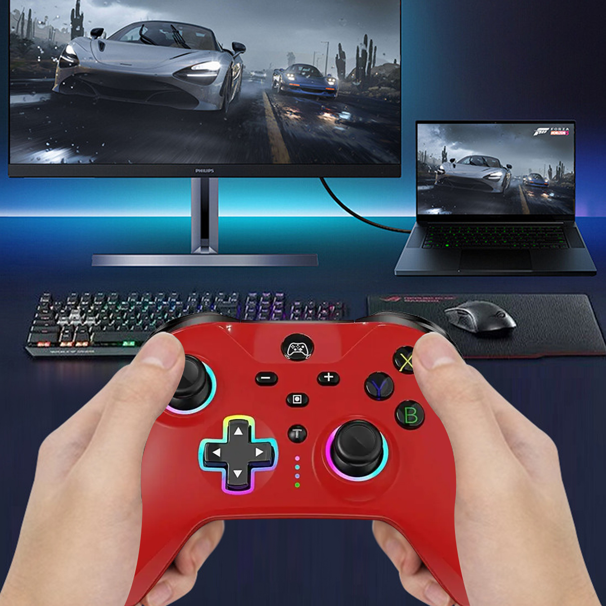 Eine Person hält einen roten Controller und spielt ein Spiel auf einem Monitor. Ein anderer Bildschirm zeigt ein Autospiel.