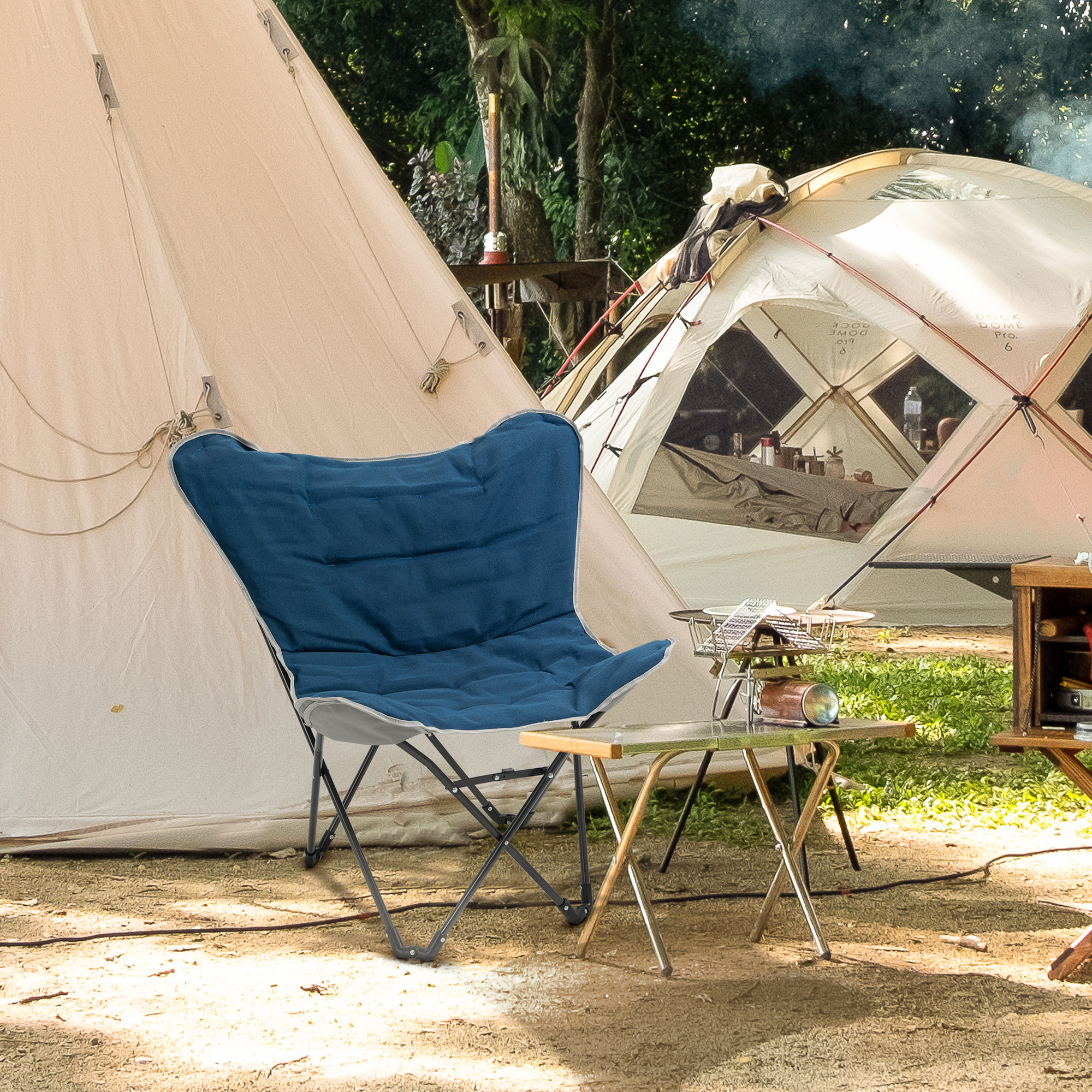 Ein blauer Schmetterlingsstuhl steht vor einem Zelt und einem kleinen Tisch, wodurch eine Campingszene entsteht.