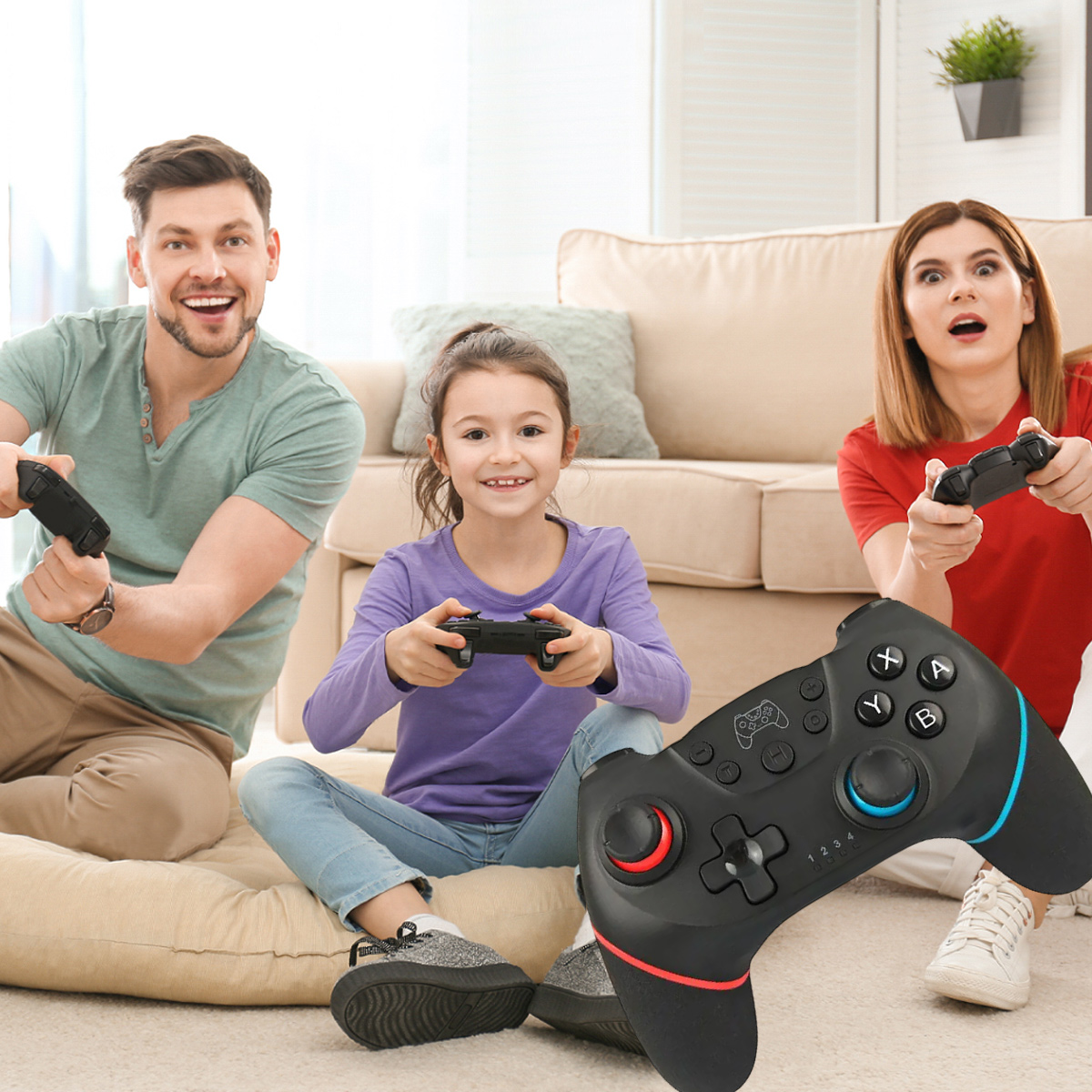 Eine Familie spielt Spiele mit Controllern. Der Controller im Vordergrund ist schwarz mit Rot und Blau.
