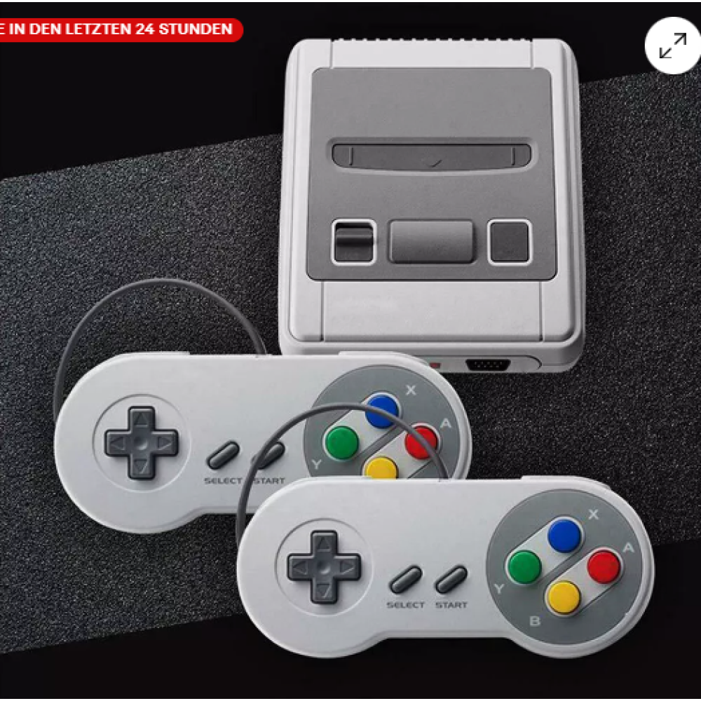 Das Bild zeigt eine Retro-Spielkonsole mit zwei Controllern. Die Konsole ist grau, und die Controller sind grau.