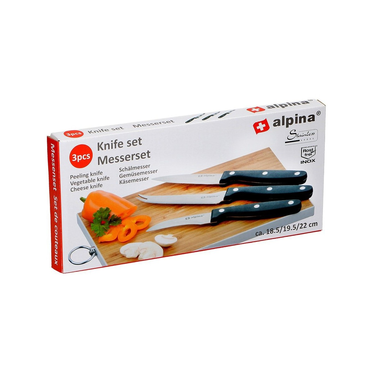Ein Messerset in einer Box, mit drei Messern auf einem Holzbrett neben einer Paprika und Pilzen.