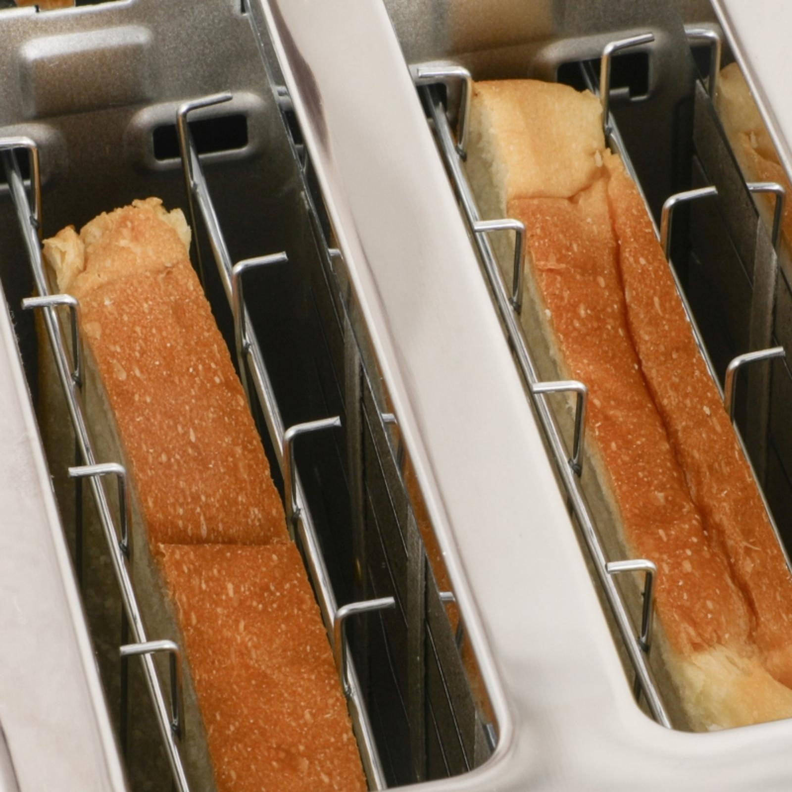 Nahaufnahme eines Toasters mit Brotscheiben. Das Brot ist getoastet. Der Toaster ist silberfarben.