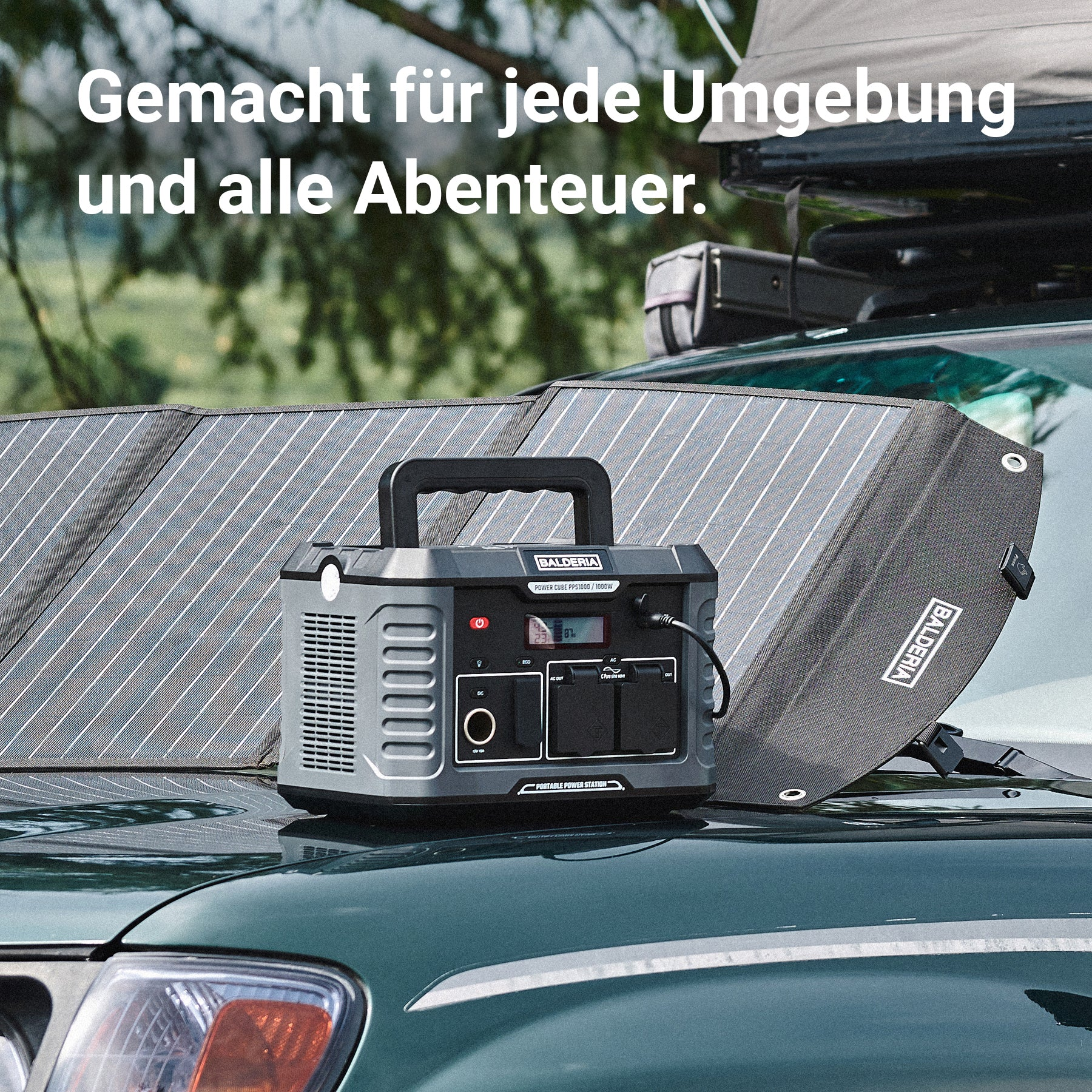 Eine tragbare Powerstation und ein Solarpanel stehen auf einer grünen Motorhaube in einer Waldumgebung.