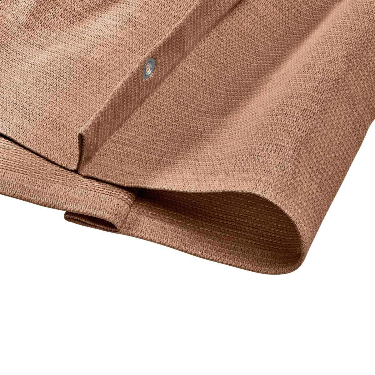 Gros plan sur le tissu de l'auvent marron. Un œillet métallique est visible le long du bord.