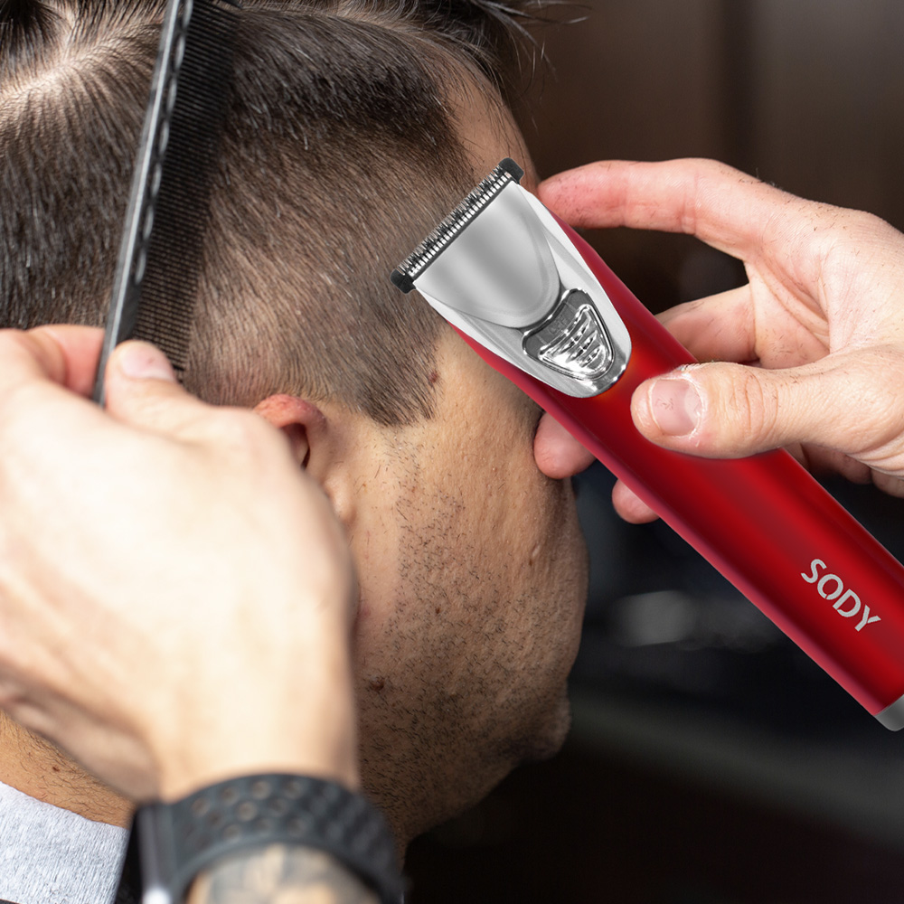 Un barbiere sta tagliando i capelli a qualcuno con un tagliacapelli rosso.