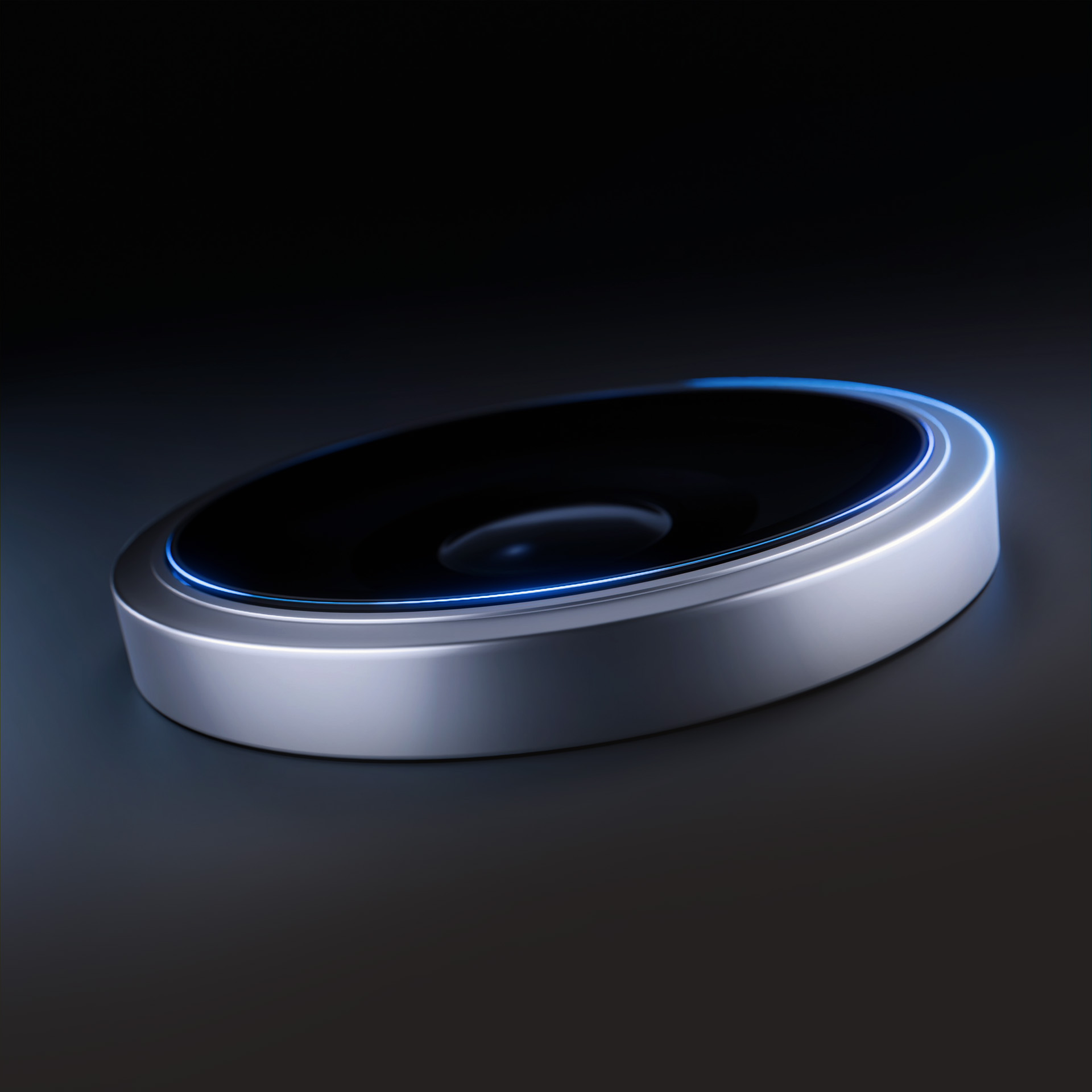 Oggetto ovale argentato con centro nero e luce blu. Sfondo scuro.