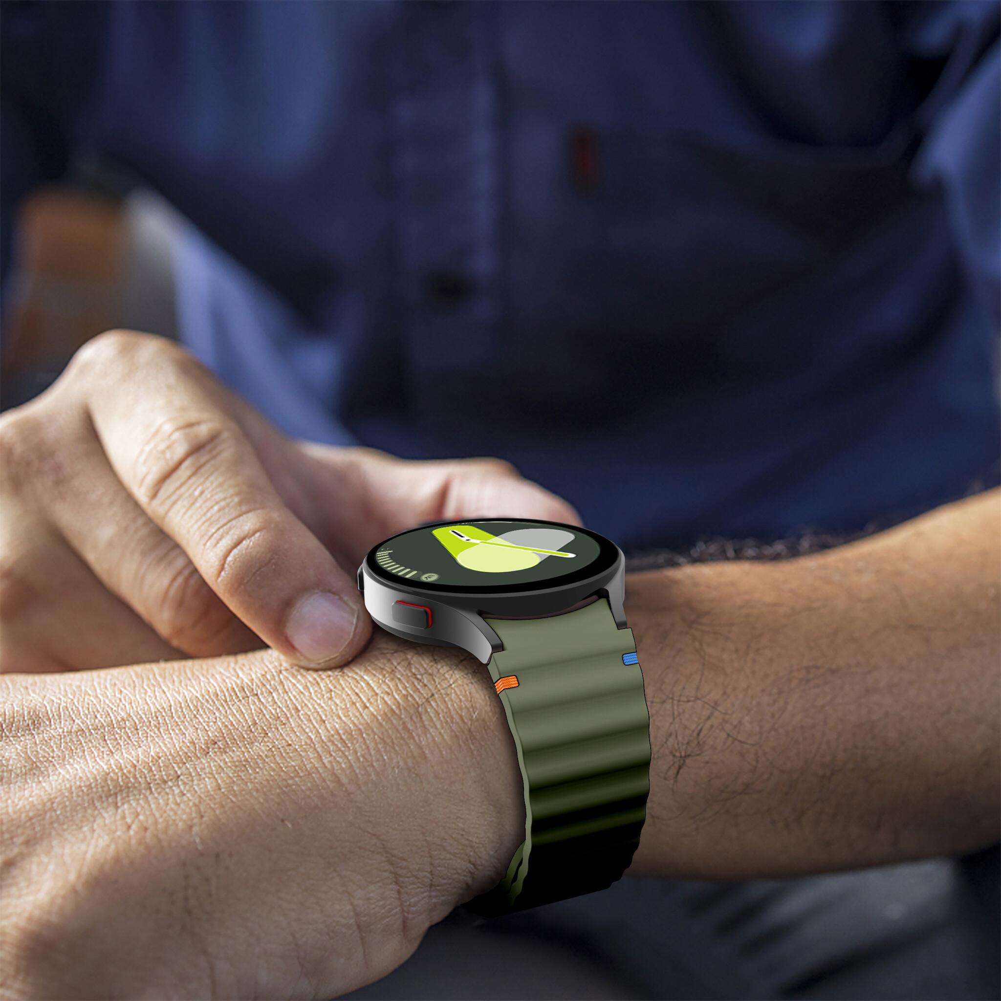 Eine Person trägt eine Smartwatch mit grünem Armband, das Zifferblatt zeigt eine schwarze Grafik.