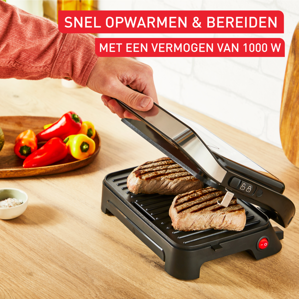 Grill z dwoma stekami, które są dociskane grillem. Tekst mówi 'Snel opwarmen & bereiden met een vermogen van 1000 W'.