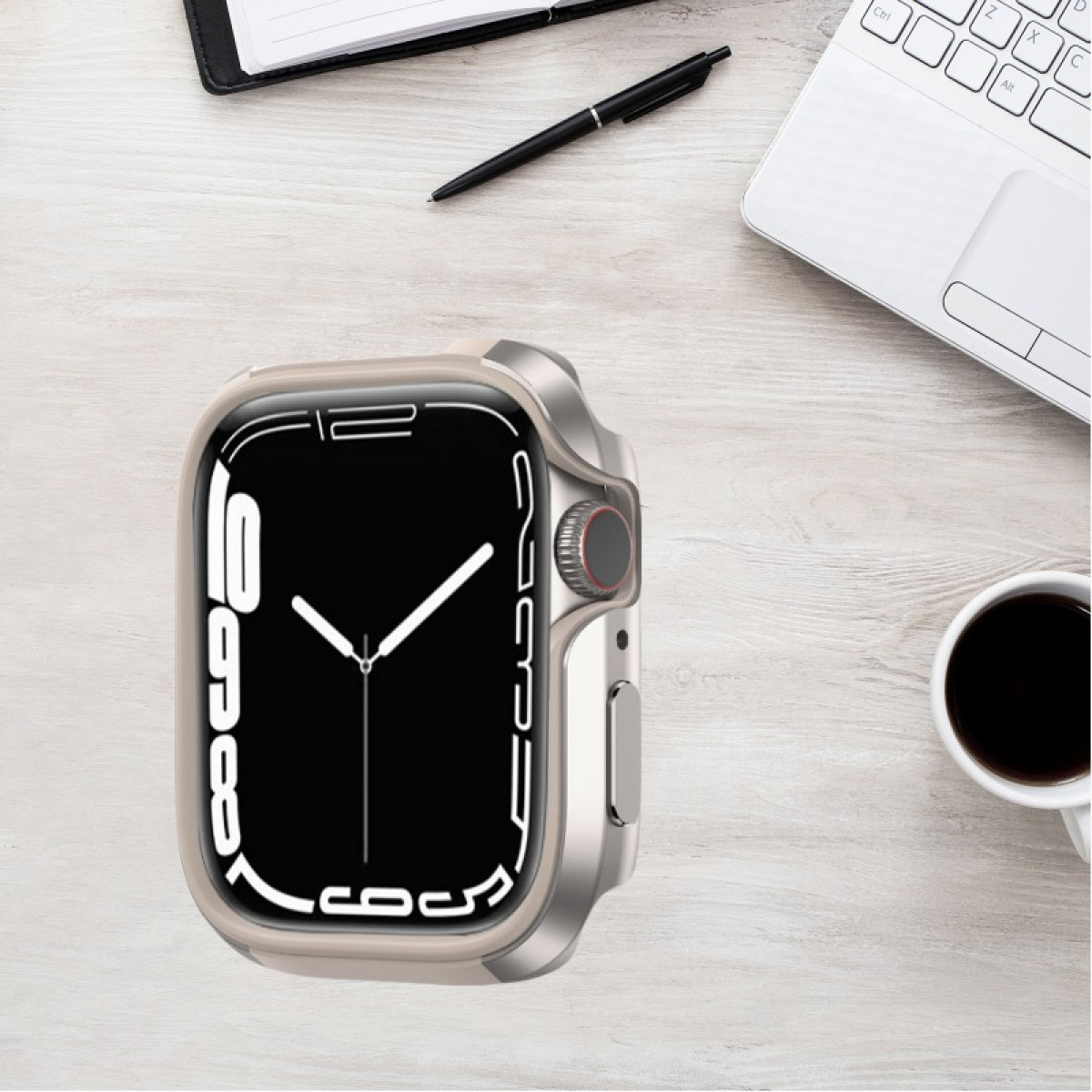 Uno smartwatch in una custodia su una scrivania di legno con penna, laptop e tazza di caffè.