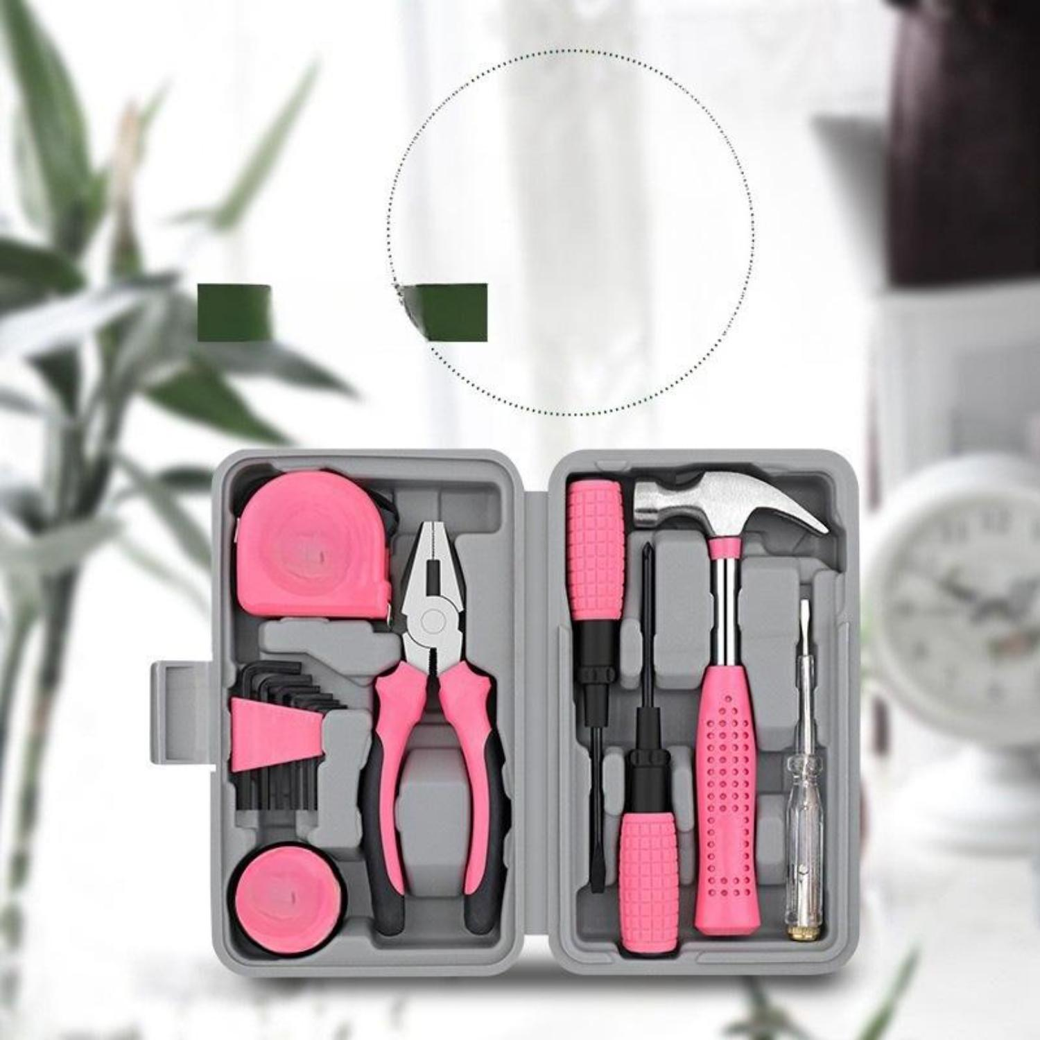 Ein rosa Werkzeugset in einem grauen Koffer, einschließlich Hammer, Schraubendreher, Zange und Maßband.