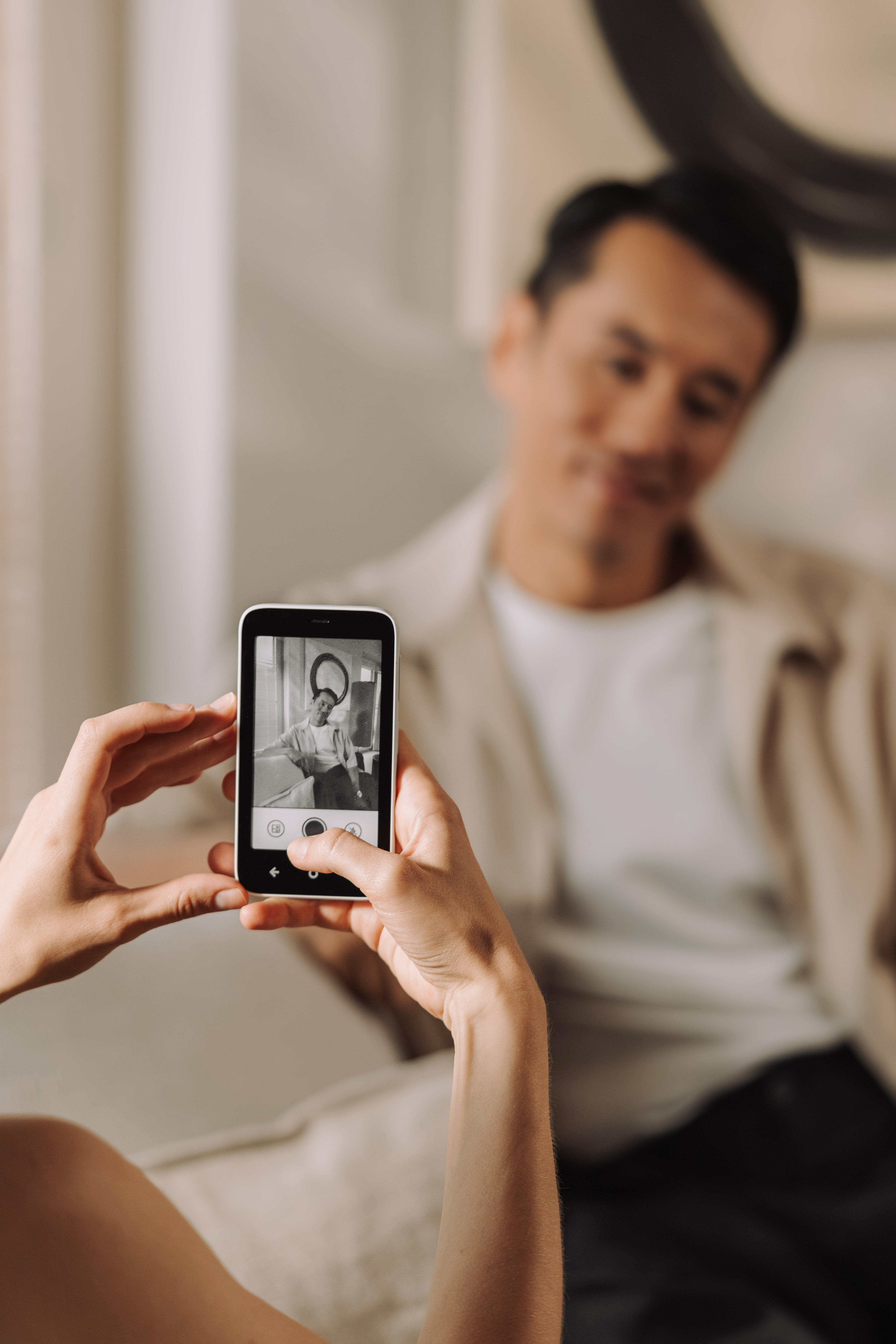 Eine Person hält ein Smartphone und macht ein Foto von einer anderen Person.
