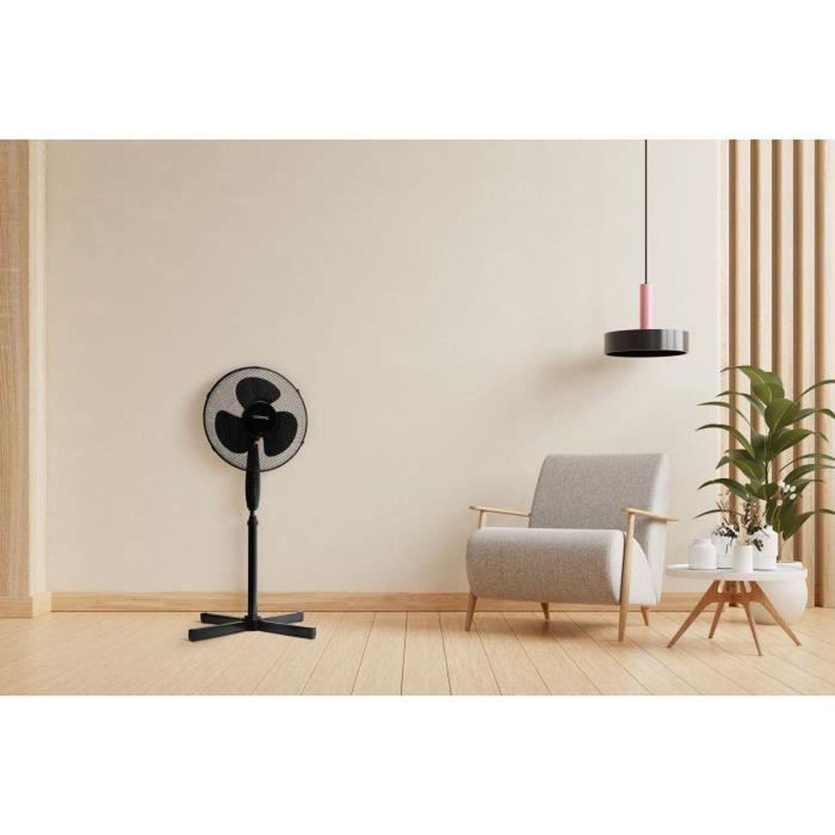 Ein schwarzer Ventilator steht in einem Raum. Im Hintergrund sind ein Stuhl, eine Hängelampe und eine Pflanze.