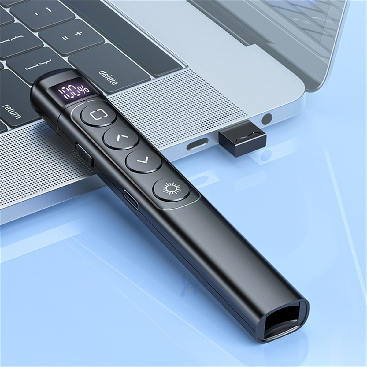 Schwarzer Präsentationsstift mit Knöpfen und Display, neben einem Laptop mit USB-Empfänger.