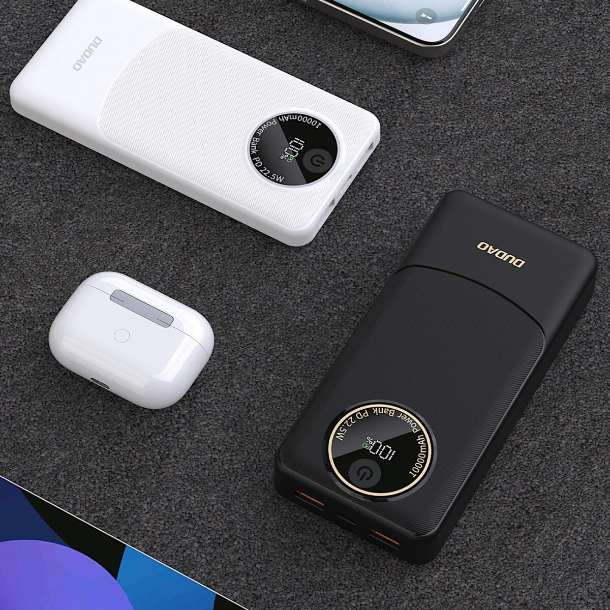 Power banki i słuchawki AirPods na ciemnej powierzchni. Jeden biały, jeden czarny power bank. Etui AirPods.