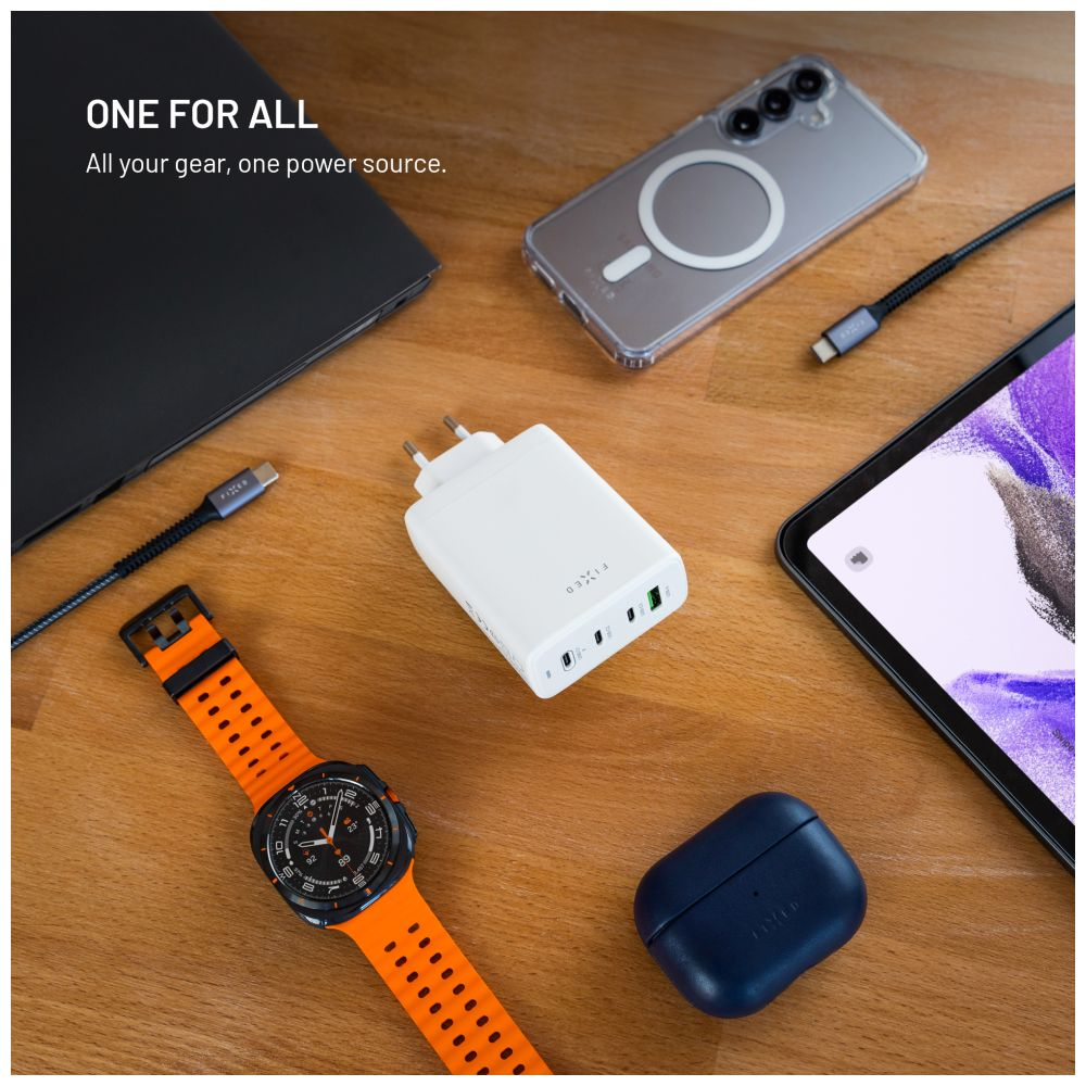 Ein Holztisch mit vielen Accessoires: ein Ladegerät, ein Tablet, eine Uhr, ein Telefon, kabellose Ohrhörer. Alles ordentlich angeordnet.