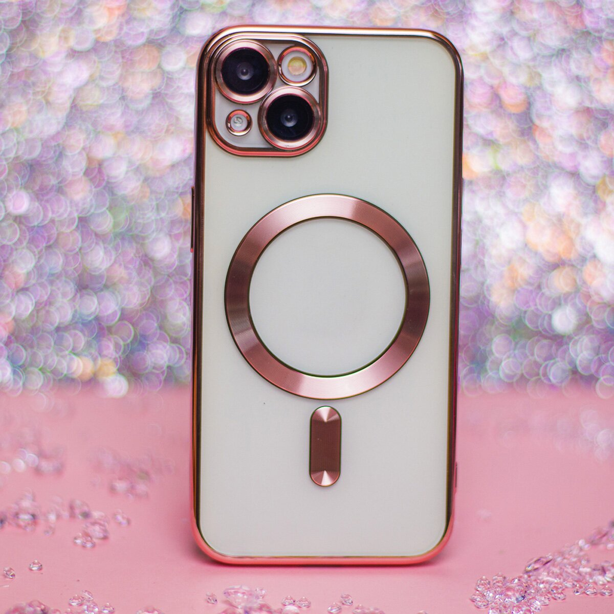 Eine Handyhülle mit roségoldfarbenen Akzenten auf rosa Hintergrund. Die Hülle ist auf einem weißen Telefon.