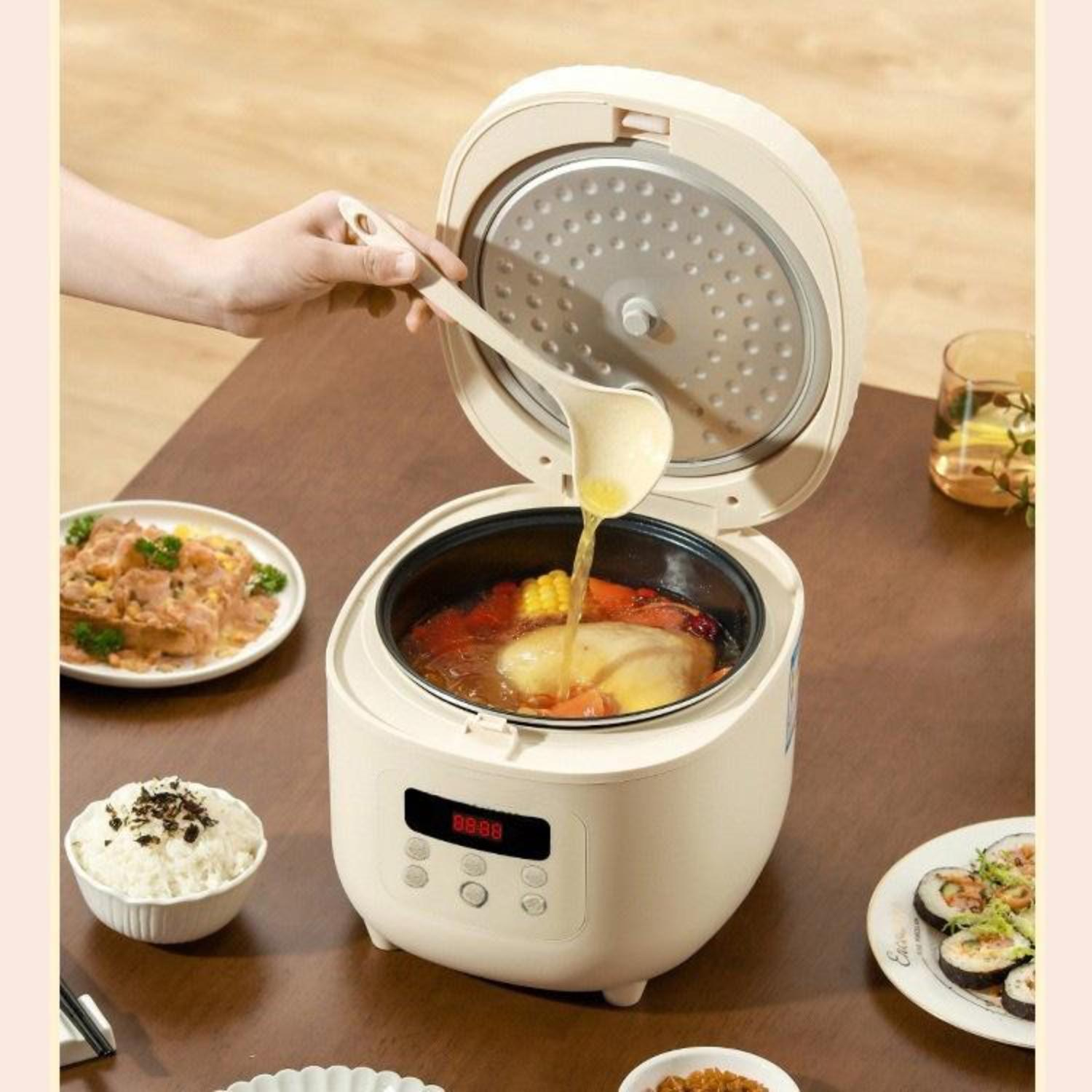 Ein beiger Reiskocher, geöffnet, um Essen zu zeigen. Eine Hand gießt Flüssigkeit mit einem Löffel hinein.