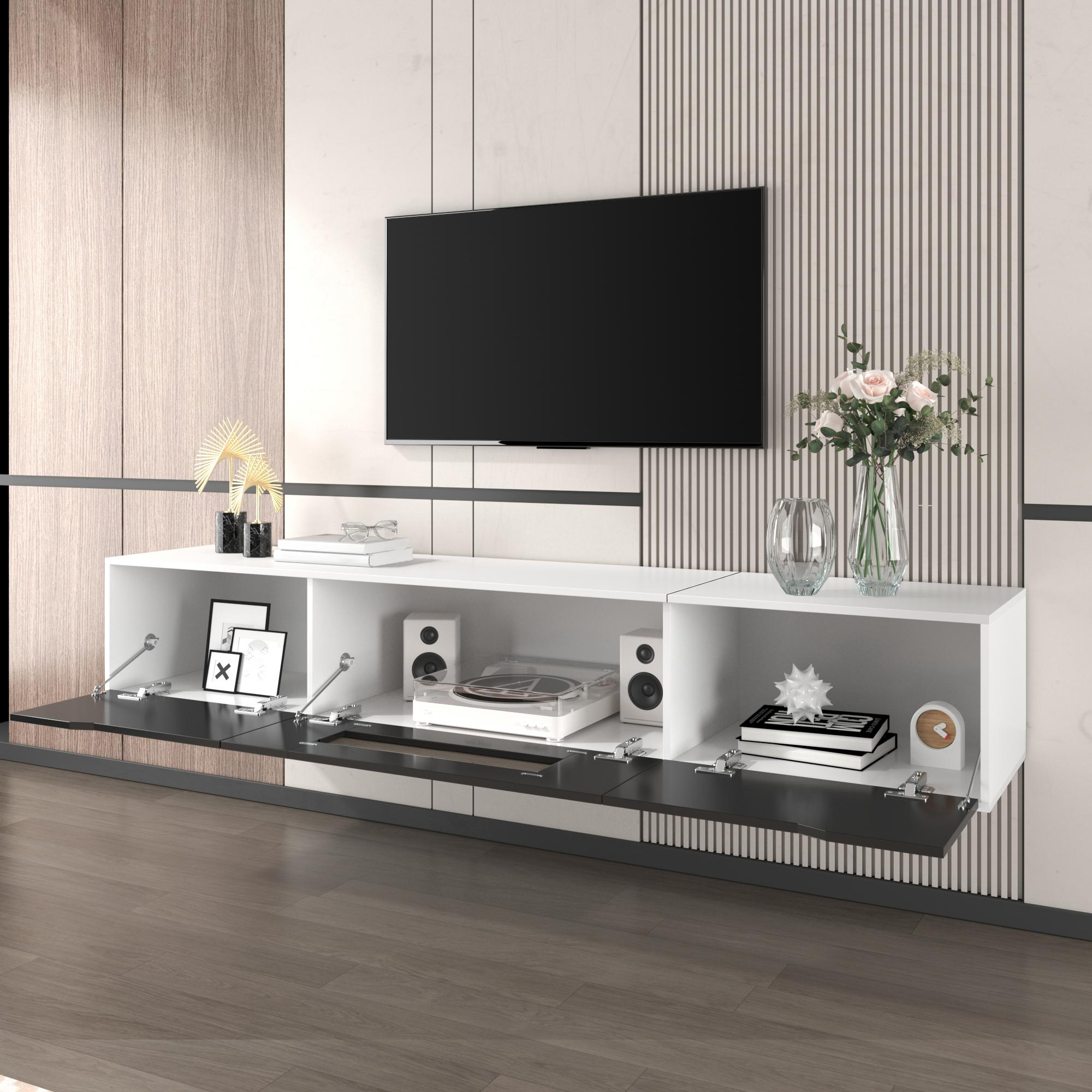 Ein moderner, weiß-schwarzer, an der Wand befestigter Schrank mit Fernseher, Lautsprechern und Dekoration.