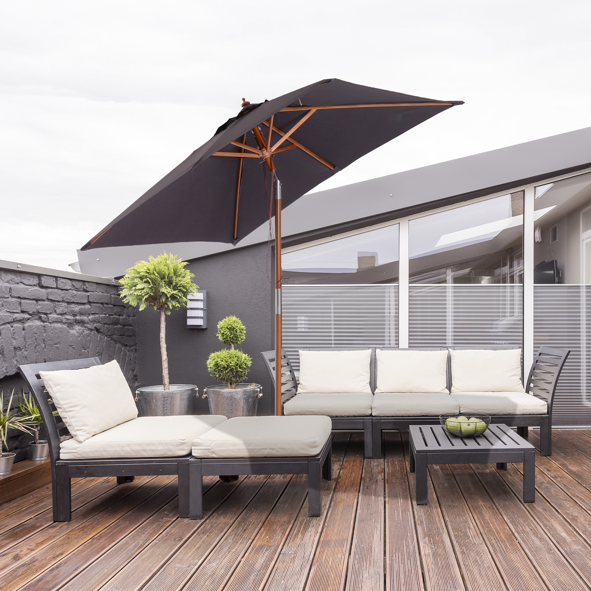 Terrassenmöbel-Set mit schwarzen Möbeln. Inklusive Sofa, Stühlen, Tisch und offenem Schirm.