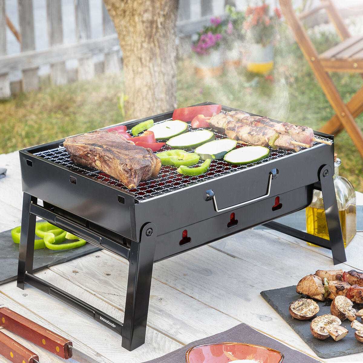 Ein schwarzer tragbarer Grill mit Essen darauf, auf einem Holztisch.