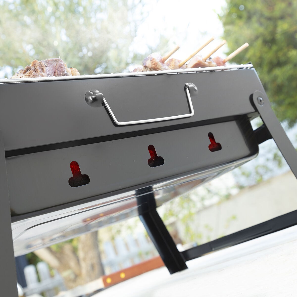 Nahaufnahme eines Grills mit Essen, Griff und Lüftungslöchern.