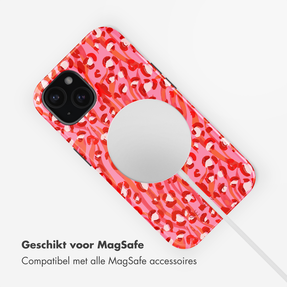 A pink and red leopard print phone case. A white cable is connected to the back. White background.