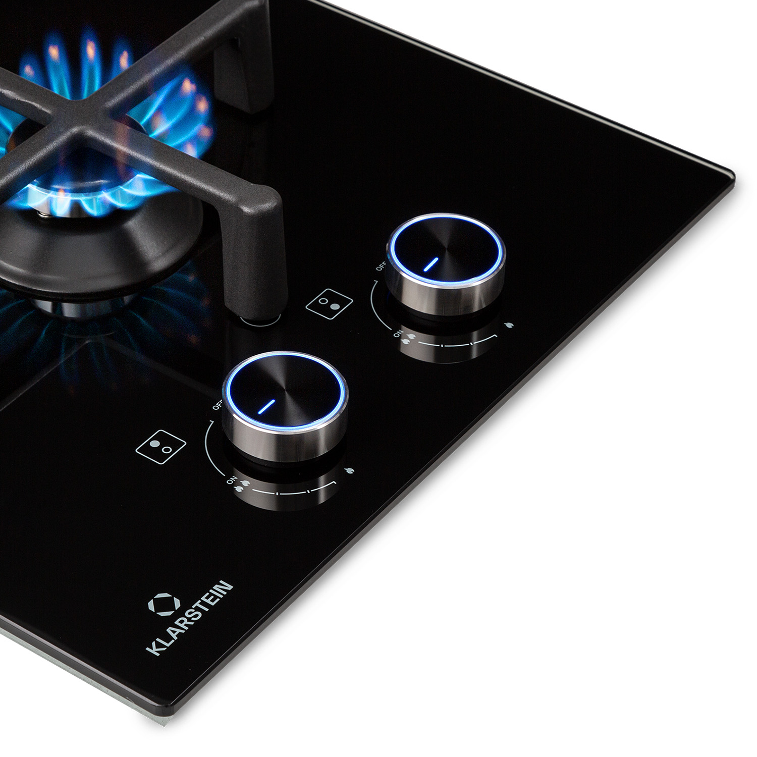 Nahaufnahme eines schwarzen Kochfelds mit silbernem Rahmen, schwarzen Knöpfen und blauen Flammen, die aus den Brennern kommen.