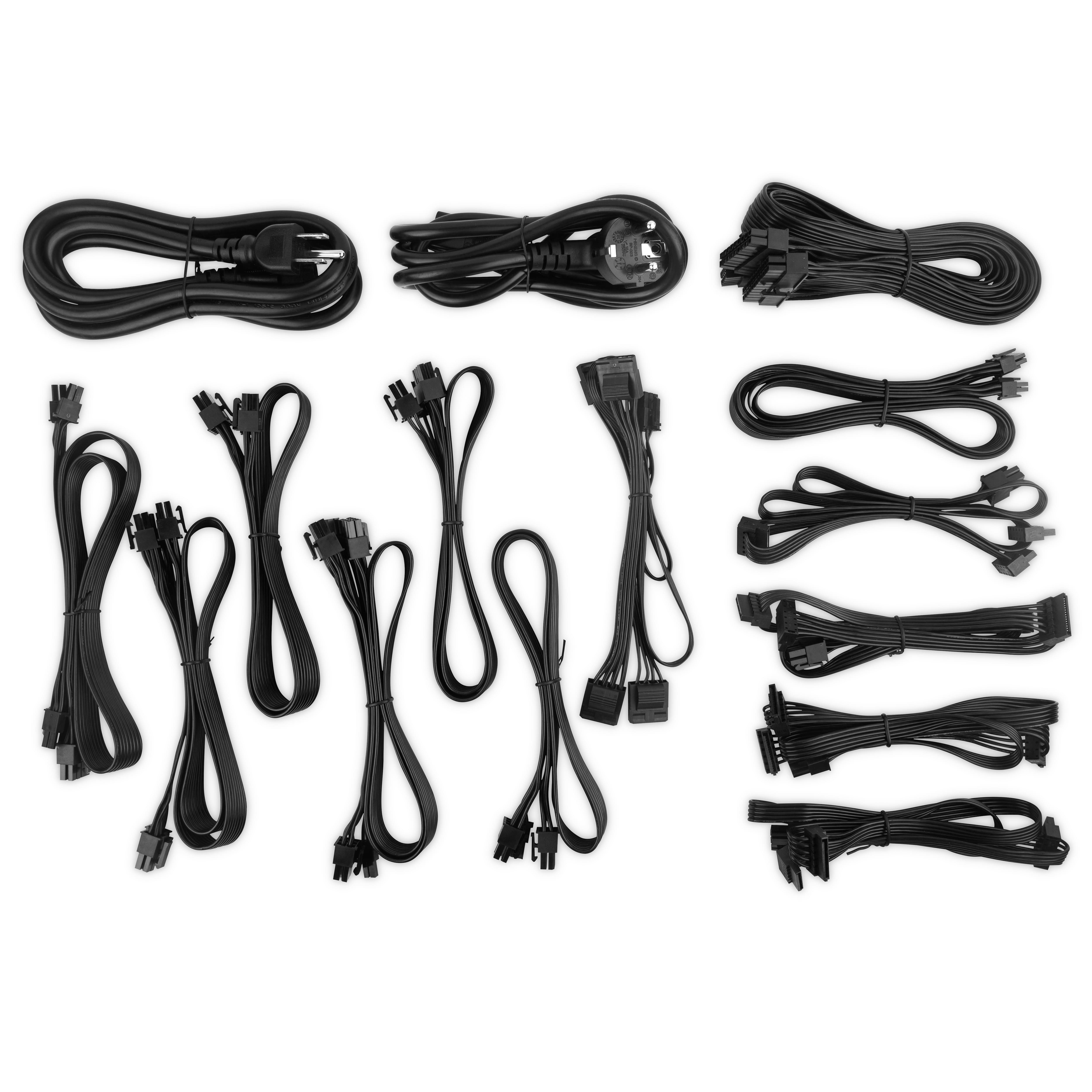 Varios cables y conectores de fuente de alimentación negros ordenados en una superficie blanca.