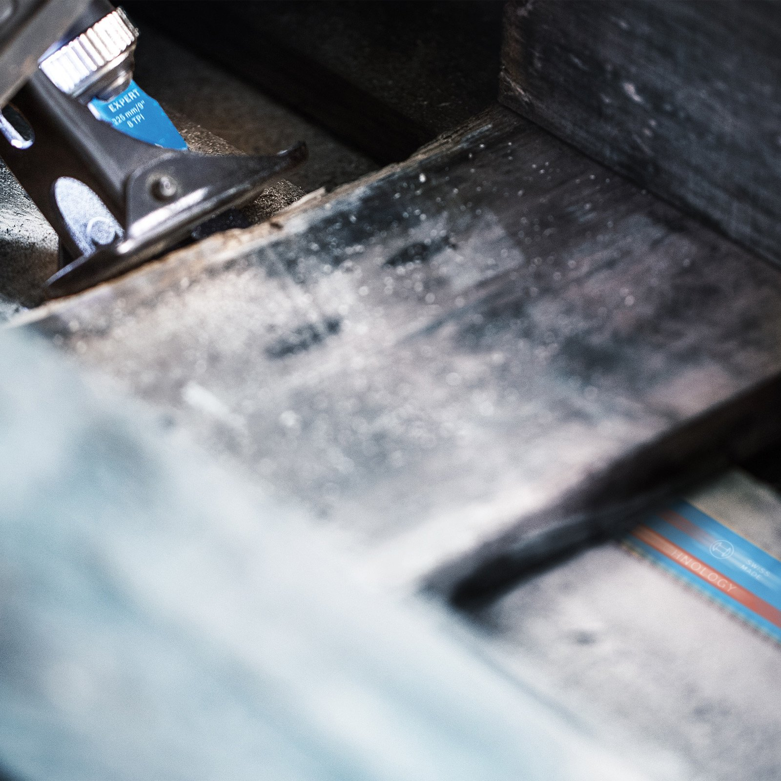 Zbliżenie brzeszczotu tnącego drewno. Widoczny niebieski brzeszczot z napisem EXPERT.