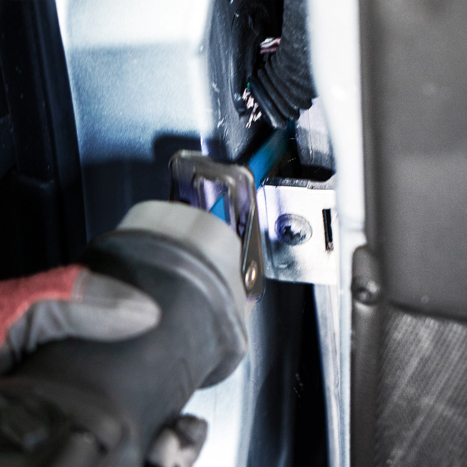 Osoba używa piły do cięcia metalowego przedmiotu.