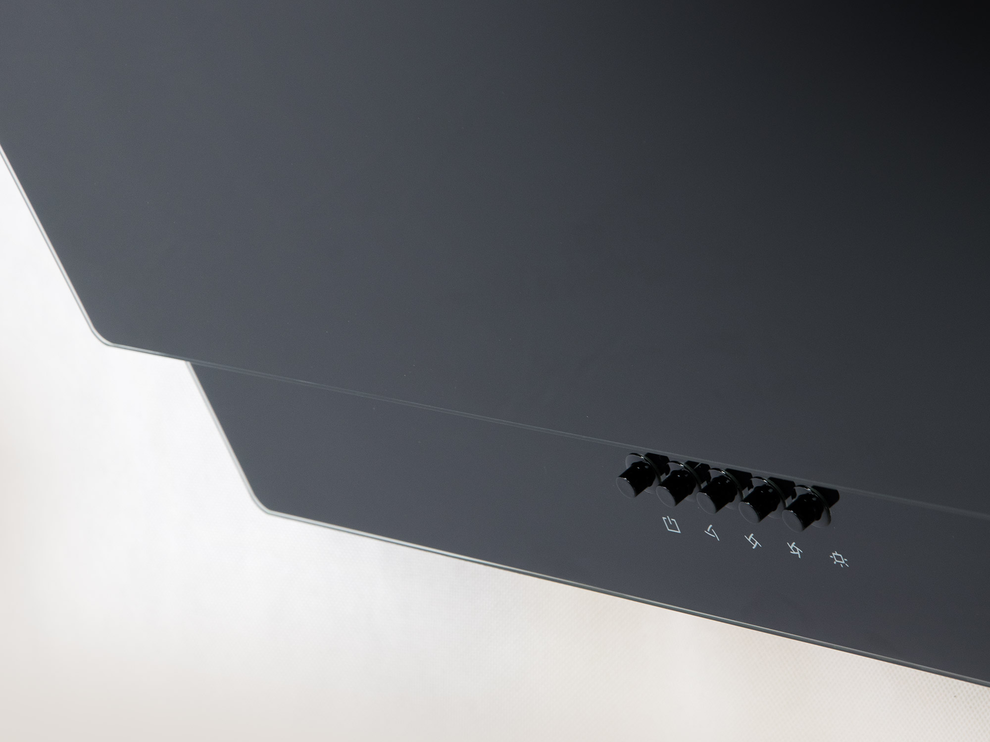 Zbliżenie pokazuje panel sterowania okapu, z kilkoma przyciskami.