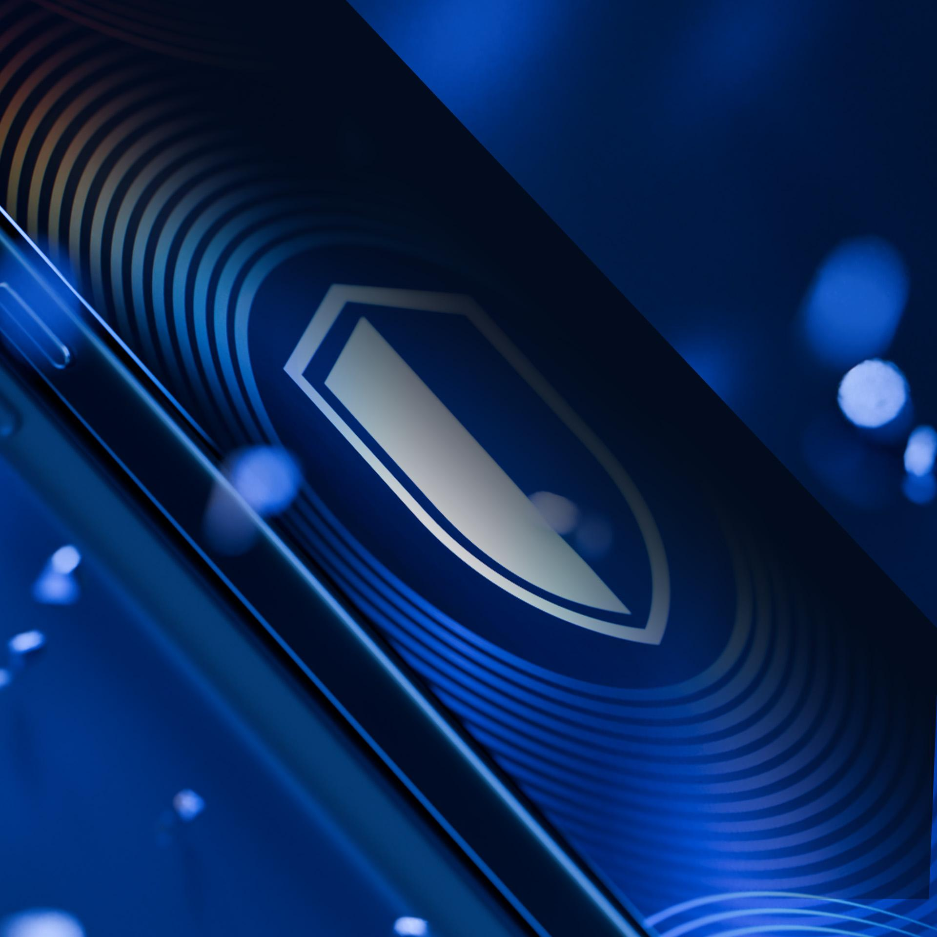 Niebieskie tło z ikoną tarczy na ekranie telefonu, sugerujące bezpieczeństwo i ochronę.