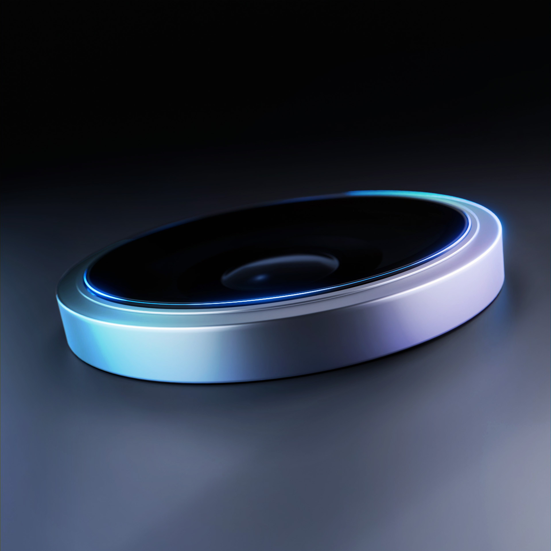 Metalowe, okrągłe urządzenie z czarnym środkiem i niebieską, podświetloną krawędzią na ciemnym tle.