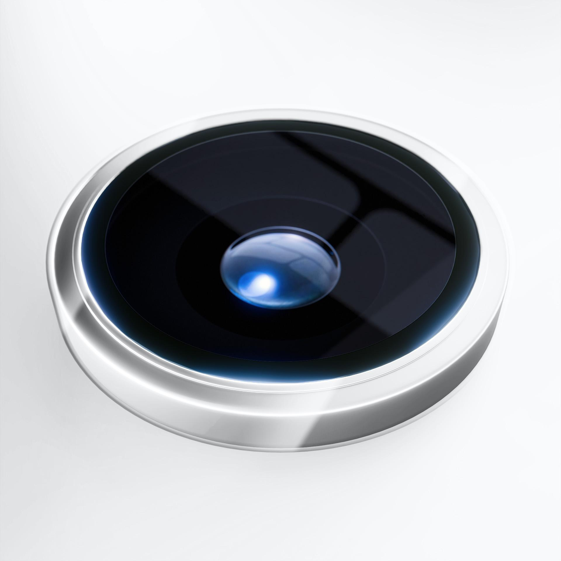 Zbliżenie obiektywu aparatu w telefonie. Ma czarne centrum otoczone srebrnym pierścieniem na białym tle.