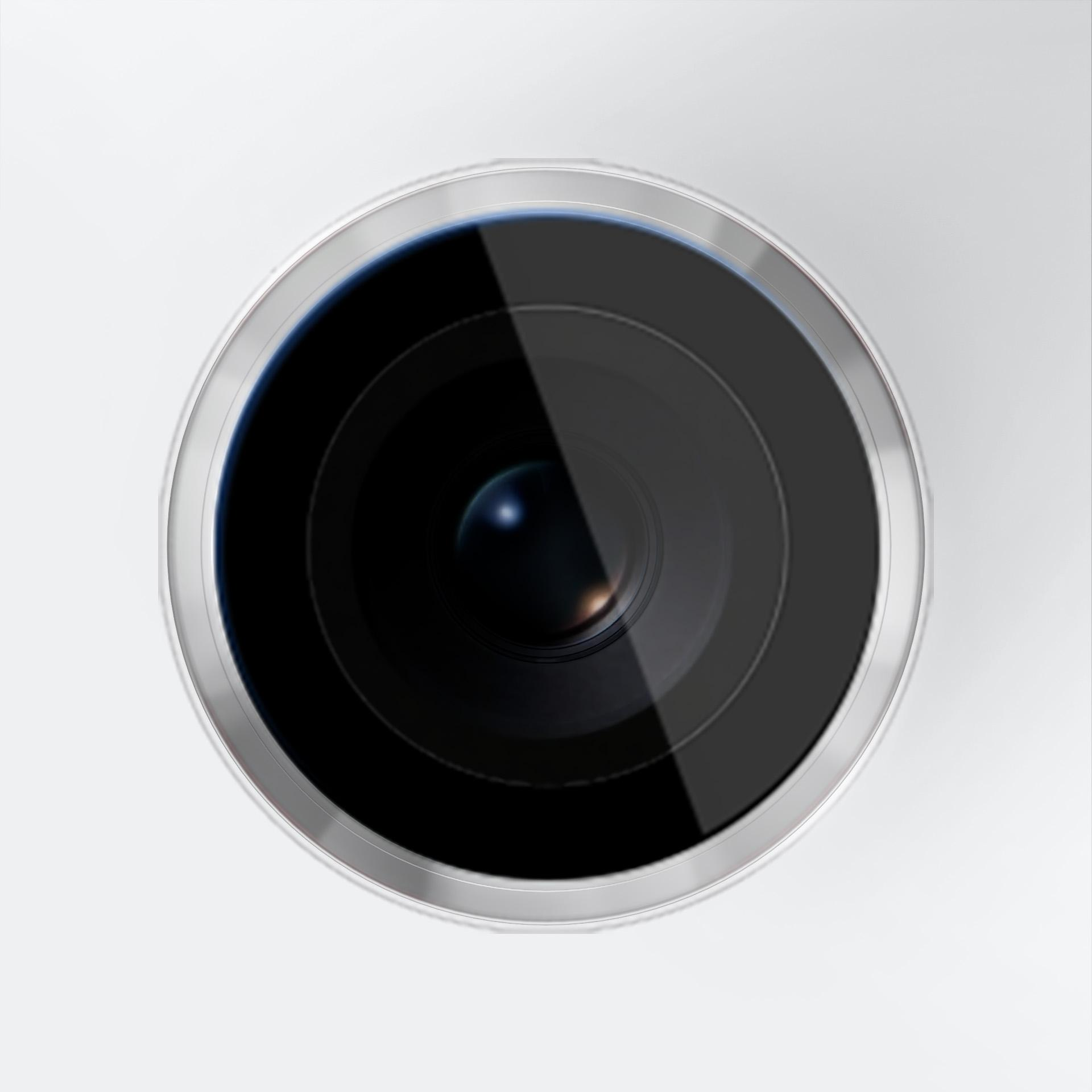 Zbliżenie obiektywu aparatu. Czarne szkło otoczone srebrnym metalowym pierścieniem na białym tle.
