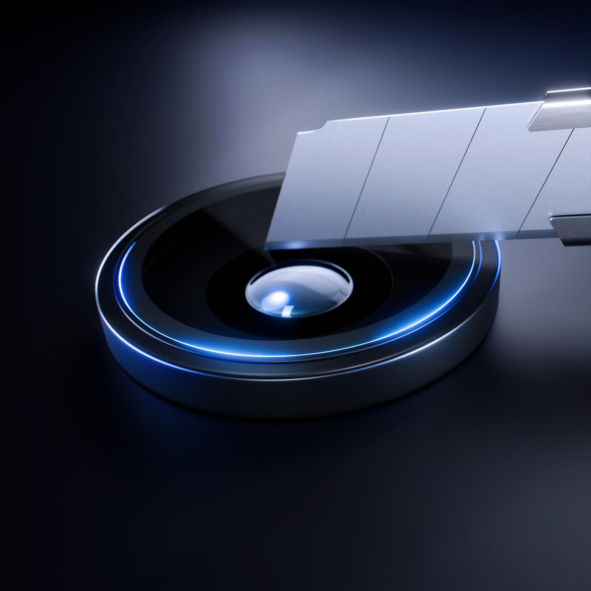 Metalowe ostrze do golenia nad okrągłym, czarnym obiektem z niebieskim neonowym konturem, na ciemnym tle.