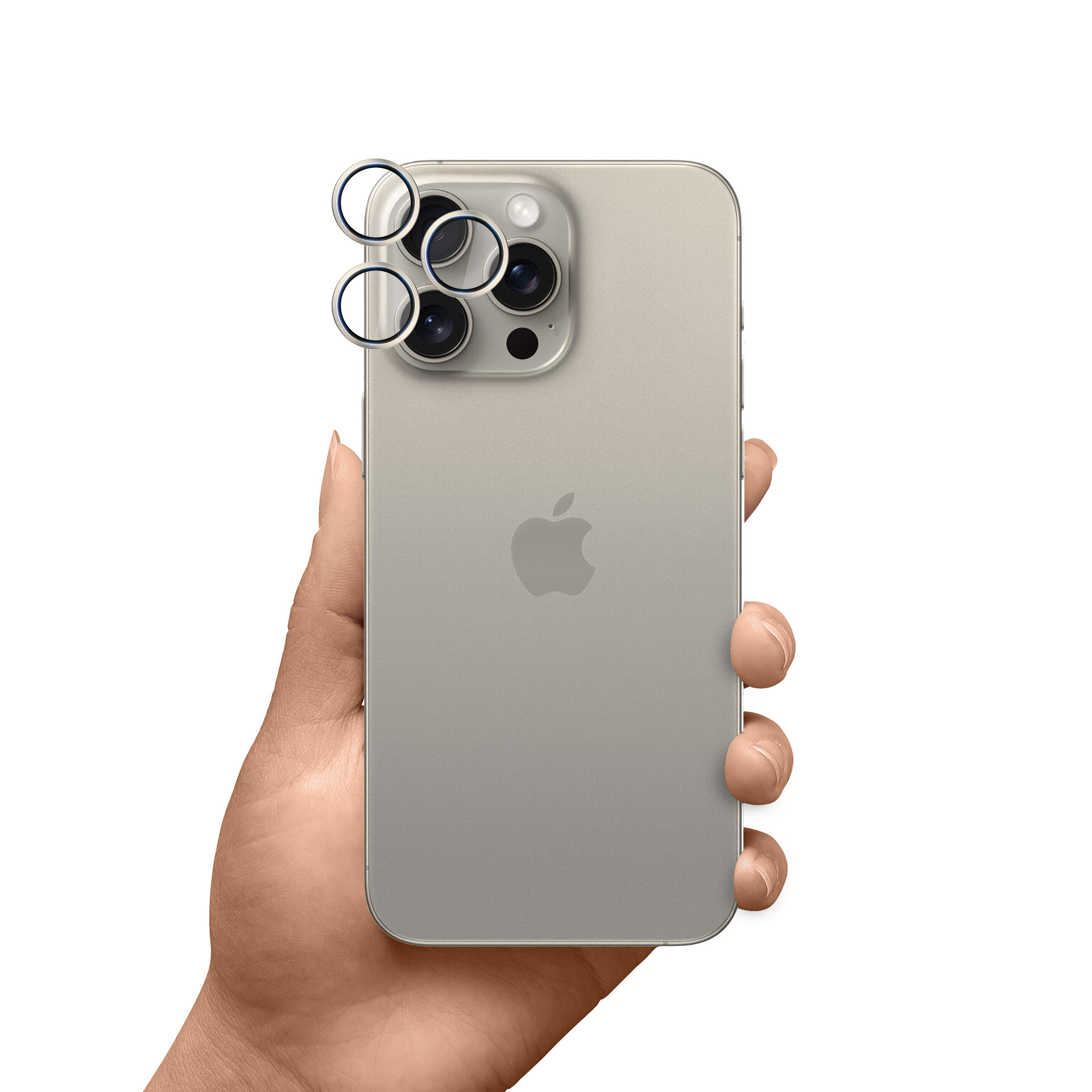 Dłoń trzyma srebrny iPhone z trzema osłonami obiektywu. Logo Apple jest widoczne z tyłu.